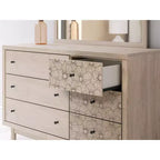 Commode 6 tiroirs Signature Design by Ashley Birkmore, finition chêne clair avec accents floraux, couleur havane